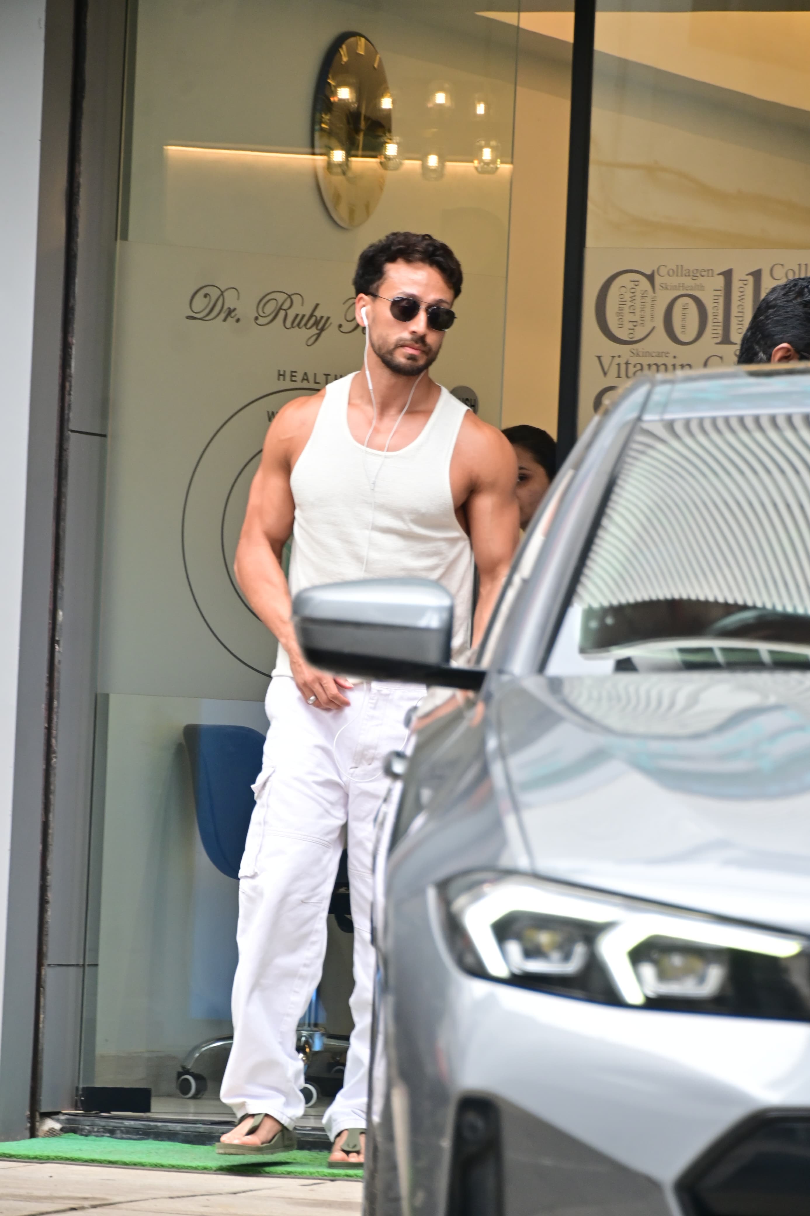 Tiger Shroff was spotted in Bandra this afternoon in white pants and a white vest, showing off his muscles. 